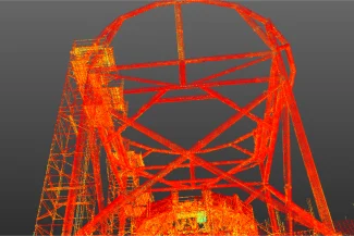 Una nube de puntos digital muestra una gran estructura geométrica de acero con una parte superior circular, vista desde abajo sobre un fondo gris. La estructura inspirada en el NAICM se representa en tonos rojos, naranjas y amarillos.