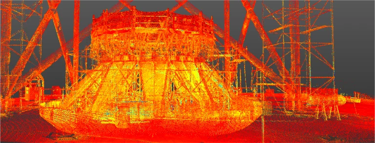 Una vibrante nube de puntos 3D escaneada en rojo, amarillo y naranja muestra una gran estructura industrial cilíndrica del emplazamiento del NAICM Texcoco, rodeada de andamios y vigas de soporte sobre un fondo oscuro