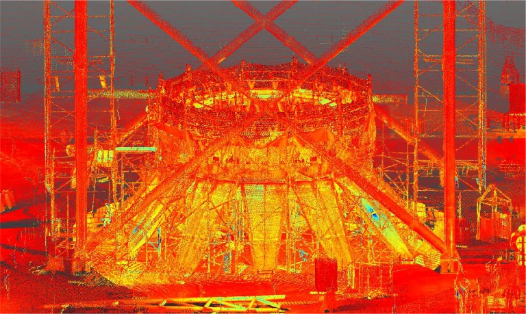 Imagen de escaneo lidar de una gran estructura industrial circular en construcción en Texcoco, con andamios, vigas y soportes visibles en tonos rojos, naranjas y amarillos brillantes