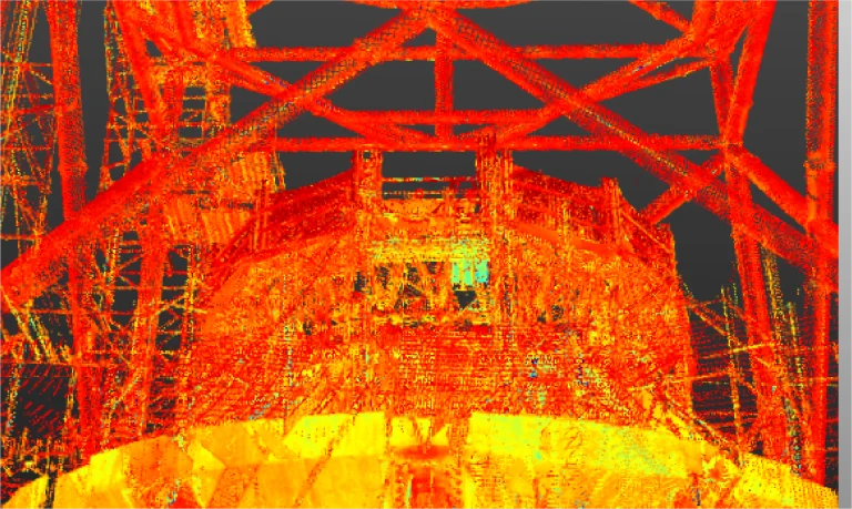 Un escaneado digital de nubes de puntos muestra el entramado estructural naranja y amarillo de una gran estructura industrial o arquitectónica, posiblemente inspirada en el proyecto NAICM de Texcoco, con vigas que se cruzan y formas geométricas sobre un fondo oscuro