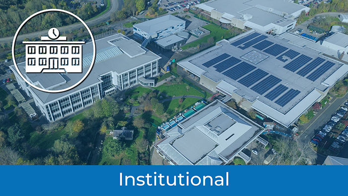 Aerial view of a large institutional building complex with solar panels on the roof, surrounded by greenery. An illustrated icon of a building is in the upper left corner. Laser Scanner Construction Technology enhances site accuracy. Institutional appears at the bottom.