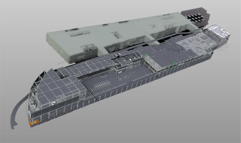 Modelo digital 3D de un aparcamiento de varios niveles en el Centro Comercial Punto Sur, conectado a un gran edificio mediante pasarelas, con plazas de aparcamiento señalizadas y rampas visibles en el interior de la estructura