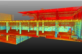 Un escaneo de nube de puntos 3D colorido del interior de un edificio BOVIS, que muestra columnas estructurales, paredes y techos en varios pisos, con varias tuberías y líneas de servicios públicos expuestas visibles.