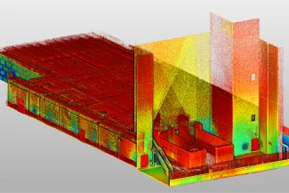 Nube de puntos 3D colorido de una nube de puntos del interior de un edificio industrial de BOVIS, que muestra detalles arquitectónicos y maquinaria, con diferentes colores que representan la altura o la profundidad.