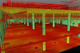 Un escaneo de nube de puntos 3D codificado por colores del interior de un edificio EQUINIX muestra columnas, pisos y vigas, con puntos rojos, amarillos y azules que representan diferentes elevaciones o materiales.