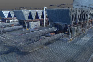 nube de puntos de una instalación industrial, como EQUINIX Bodega, que muestra grandes unidades HVAC conectadas por tuberías gruesas sobre un piso de metal enrejado, con estructuras complejas y maquinaria visibles en una visualización 3D similar a una malla.