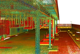 nube de puntos 3D de una estructura exterior cubierta en Bodega, que presenta vigas verticales, barandillas y un suelo pavimentado (probablemente a partir de un estudio láser), representado en puntos vibrantes de color rojo, verde, azul y amarillo.