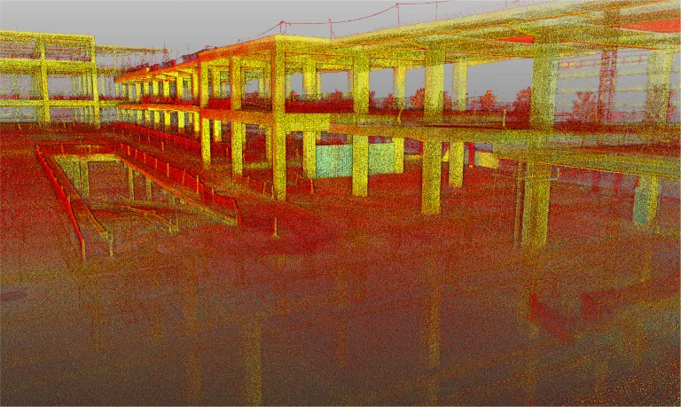 Una colorida nube de puntos escaneada en 3D del Centro Comercial Punto Sur, que captura el edificio de varias plantas en construcción con columnas, vigas y plantas diáfanas en vibrantes tonos rojos, amarillos, verdes y azules