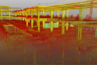 Una colorida nube de puntos del Centro Comercial Punto Sur, un edificio de varias plantas en construcción, muestra columnas y vigas a la vista y una zona central abierta con puntos rojos, amarillos y verdes dispersos.