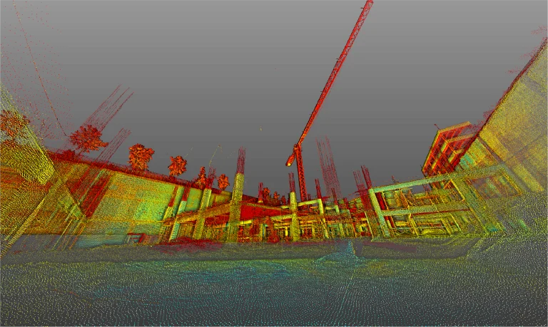 Nube de puntos 3D coloreada de la obra en construcción del Centro Comercial Punto Sur, que muestra las estructuras del edificio, columnas y una grúa alta, con árboles y estructuras parcialmente construidas de fondo bajo un cielo gris