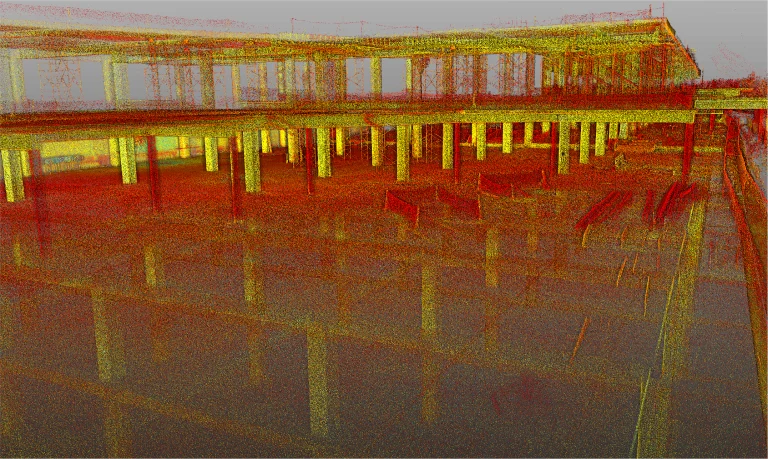 Imagen de nube de puntos escaneada con láser 3D del Centro Comercial Punto Sur en construcción, que muestra columnas estructurales, suelos y vigas en puntos rojos, amarillos y verdes. Los reflejos aparecen en la superficie brillante del suelo