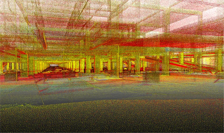 Una nube de puntos digital del interior del Centro Comercial Punto Sur, que muestra columnas estructurales, vigas y niveles de suelo en vibrantes puntos amarillos, rojos y verdes para conseguir un efecto semitransparente similar al de un wireframe