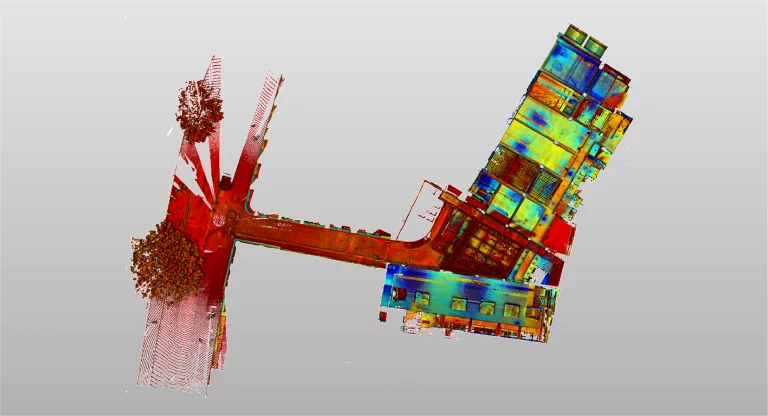 Nube de puntos que muestra una calle con árboles a la izquierda y el edificio Grimshaw a la derecha, utilizando un gradiente de rojo a azul para indicar diferentes elevaciones o valores de datos