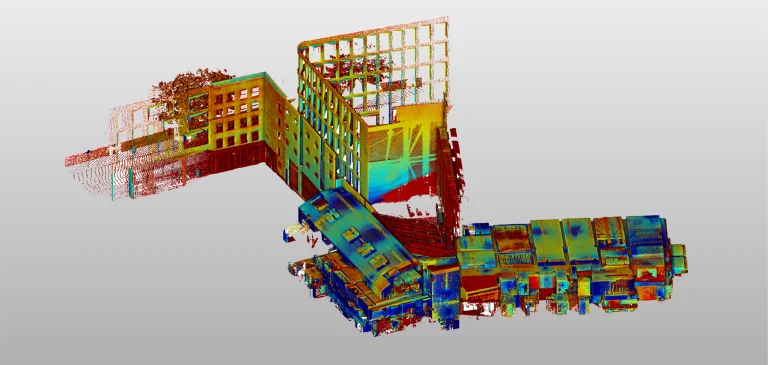 Un colorido modelo de nube de puntos 3D de edificios en intersección, incluido el edificio Grimshaw, mostrado desde una vista aérea en ángulo sobre un fondo gris degradado. Las ventanas rectangulares y las fachadas presentan vibrantes colores rojos, amarillos, azules y verdes