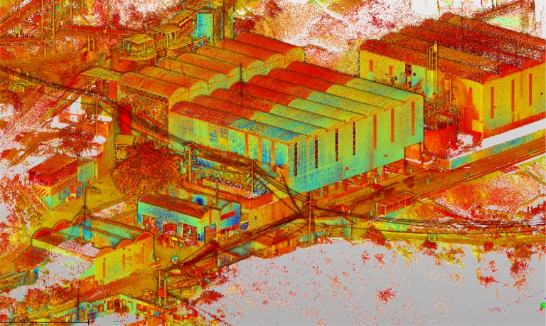 Colorida nube de puntos de la zona industrial de DIABRAS Mina con grandes almacenes, estructuras más pequeñas y árboles vistos desde un ángulo elevado. Rojos, amarillos y azules resaltan las formas de los edificios, las carreteras y la vegetación
