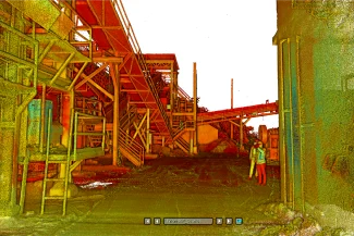 Una escena industrial distorsionada por el color en Mina DIABRAS muestra estructuras metálicas, escaleras y plataformas. Una persona con casco y chaleco de seguridad se encuentra a la derecha, cerca de un edificio. El terreno parece irregular, con escombros dispersos.