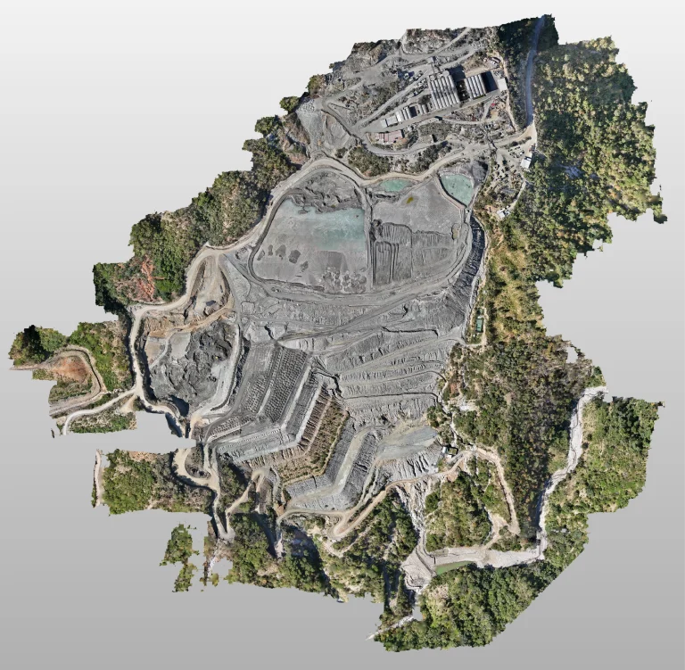 Vista aérea del emplazamiento minero a cielo abierto de Mina DIABRAS con capas aterrazadas, carreteras serpenteantes, edificios industriales y escasa vegetación verde que rodea las zonas de excavación