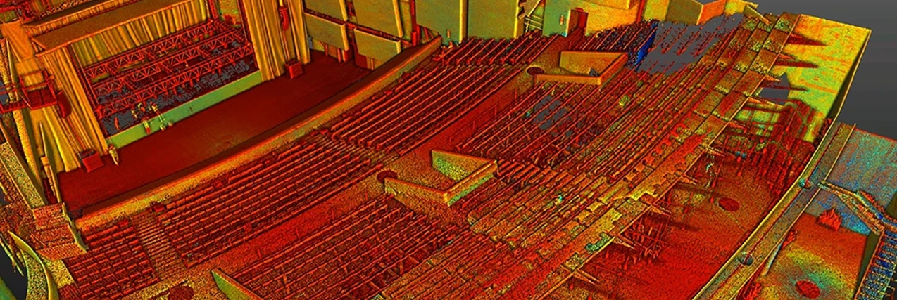 Escaneo láser en 3D del interior del Auditorio Blackberry, con nubes de puntos de colores que perfilan el escenario, los asientos y los detalles arquitectónicos en rojo, naranja, amarillo y toques de verde y azul.