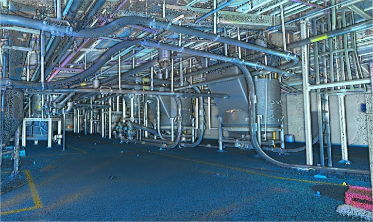 Interior industrial con numerosas tuberías, conductos y estructuras metálicas en el techo y las paredes. El espacio tenuemente iluminado, con líneas marcadas en el suelo, evoca un entorno de Mondeléz Planta Industrial o planta de transformación