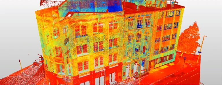 Una colorida nube de puntos escaneada en 3D del edificio GGM 115 Londres y la calle adyacente, renderizada en tonos vibrantes, muestra en detalle las características arquitectónicas y el entorno