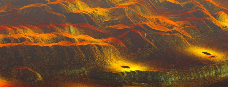 Nube de puntos de un terreno escarpado y montañoso en vivos tonos naranjas, amarillos y verdes de un Nissan Planta Industrial con brillantes puntos resplandecientes