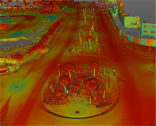 Un escaneado LiDAR aéreo coloreado de una intersección de carreteras con una rotonda cerca de Puerta de Hierro, con árboles en el centro, carreteras circundantes y edificios cercanos