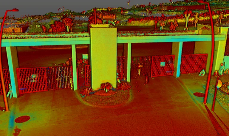 Nube de puntos de la entrada de Puerta de Hierro, con dos carriles para coches, vallas rojas y plantas ajardinadas, muestra el desarrollo de esta vivienda. Dos farolas y pequeños árboles realzan la acogedora estructura de la entrada