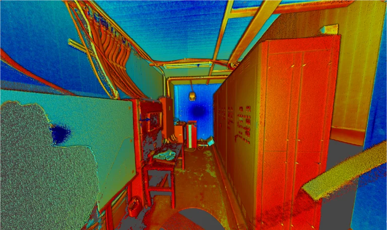 Nube de puntos 3D coloreada de una habitación estrecha de Planta Industrial Sukarne, con armarios a la derecha, paneles eléctricos y cables a la izquierda, y tonos azules, rojos y amarillos resaltando las superficies y los objetos