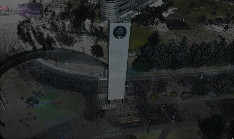 Vista aérea de la alta torre blanca con un emblema negro cerca de la cima en el Tecnológico de Monterrey, Guadalajara, rodeada de árboles, carreteras y algunos vehículos aparcados en una zona urbana