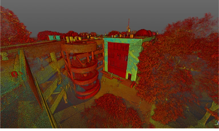Una colorida representación 3D de nubes de puntos muestra un edificio con una escalera de caracol en el Tecnológico de Monterrey, Guadalajara, rodeado de árboles y personas bajo un cielo gris. La escena se representa en tonos rojos, verdes y amarillos brillantes