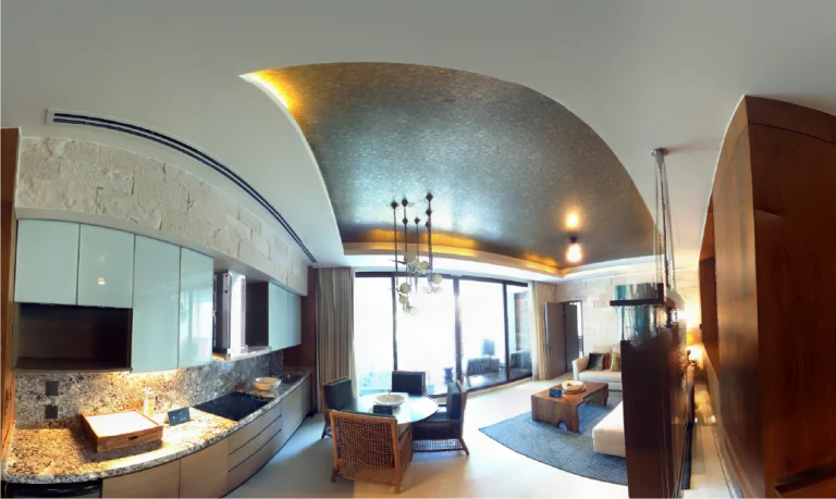 Moderna cocina de concepto abierto y sala de estar con techo curvado y texturizado, tonos neutros, armarios de madera, detalles de piedra y grandes ventanales, Acogedora zona de estar con mesa de comedor redonda