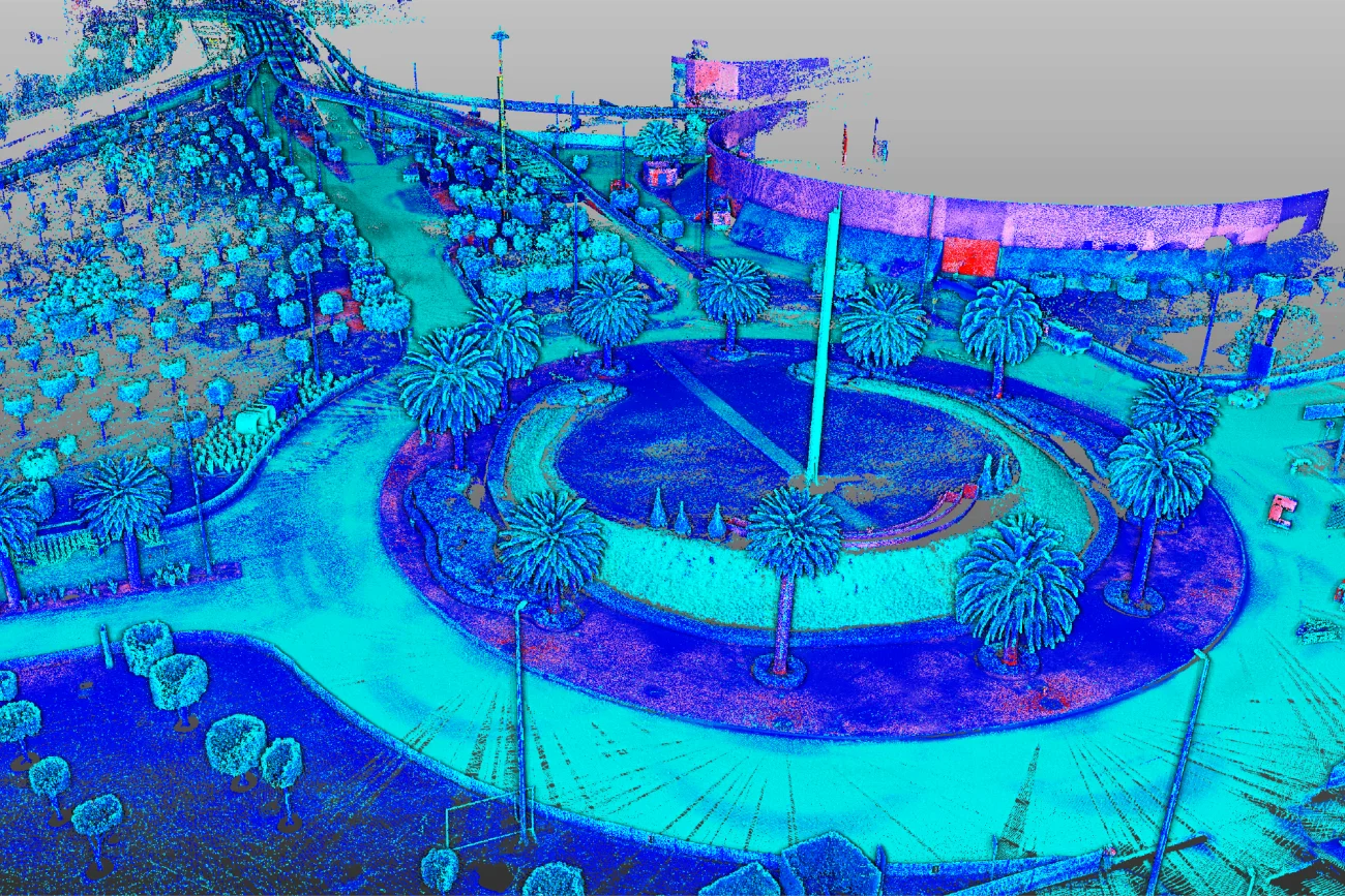 Imagen de nube de puntos colorida de un parque circular cerca del Aeropuerto Internacional de CDMX, con palmeras, senderos y un monumento central. Vista desde arriba, los gradientes de azul, verde y rosa representan la elevación o la profundidad.