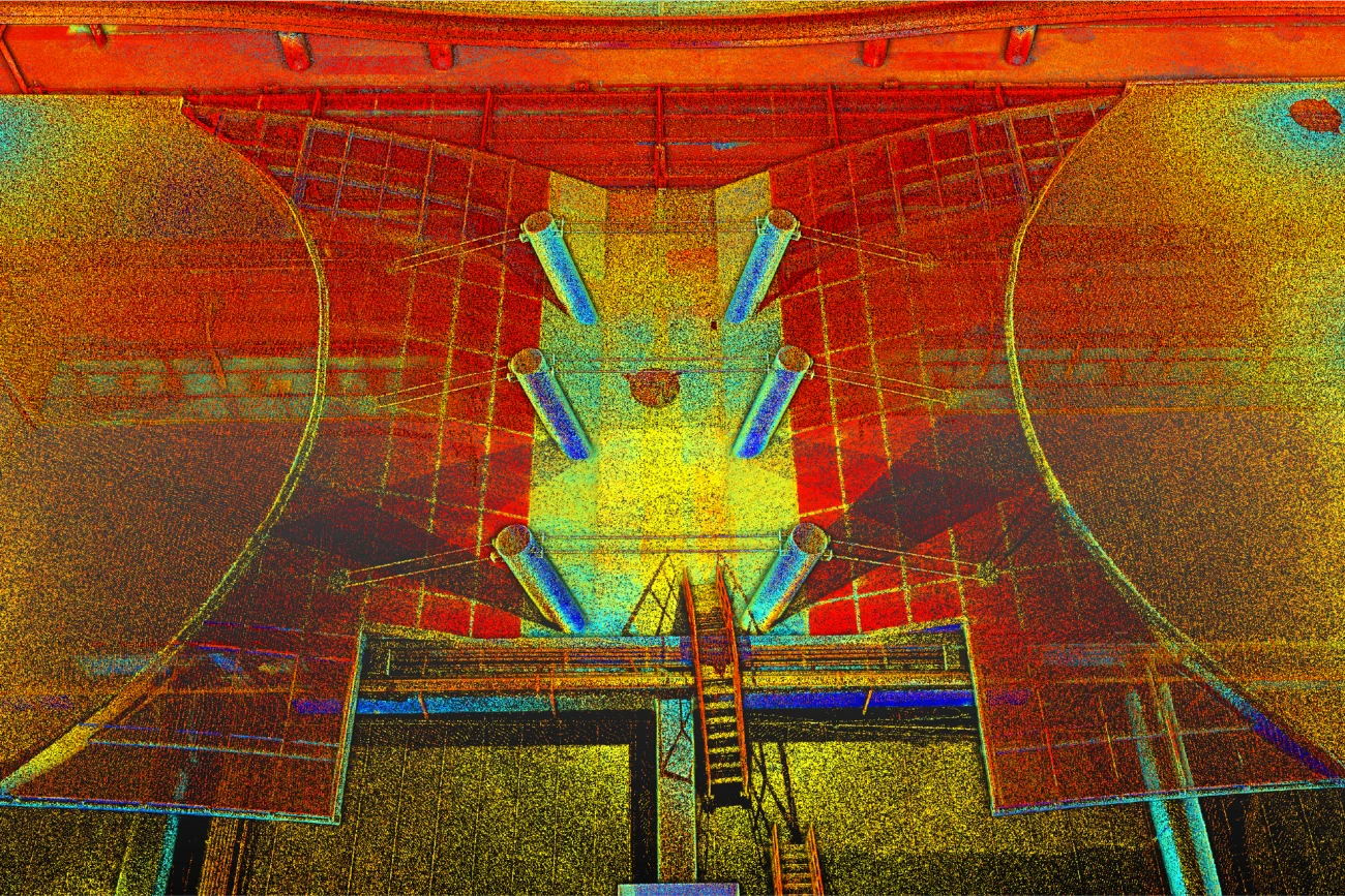 Nube de puntos de estructura industrial en el aeropuerto de Guadalajara, con paredes curvas, columnas cilíndricas y una escalera central, representada en un vibrante estilo puntillista con tonos rojos, amarillos, naranjas y azules.