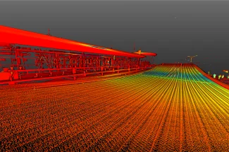 Una colorida imagen 3D de un puente cerca del aeropuerto de Guadalajara, con líneas rojas, naranjas, amarillas y verdes que representan la carretera y las barandillas, sobre un cielo gris oscuro.