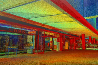 Imagen nube de puntos de colores vivos de un pasillo de un centro comercial, que recuerda al diseño moderno del Aeropuerto Internacional de Tijuana, con reflejos de escaparates de cristal bajo un techo geométrico.