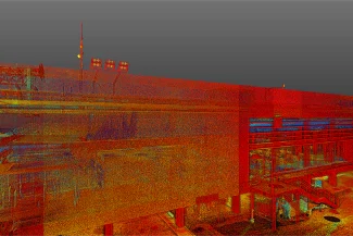 Una colorida nube de puntos escaneada en 3D del moderno exterior del Aeropuerto Internacional de Tijuana, que muestra puntos rojos, naranjas, amarillos y azules con escaleras visibles y ventanas de cristal bajo un cielo gris.