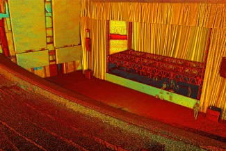 Nube de puntos de sala de conciertos vacía en Ciudad de México con filas de asientos y un escenario cubierto por cortinas amarillas, vista desde un ángulo elevado. El efecto surrealista y colorido se asemeja a un filtro de mapa de calor, evocando la vibrante energía del Auditorio Blackberry.