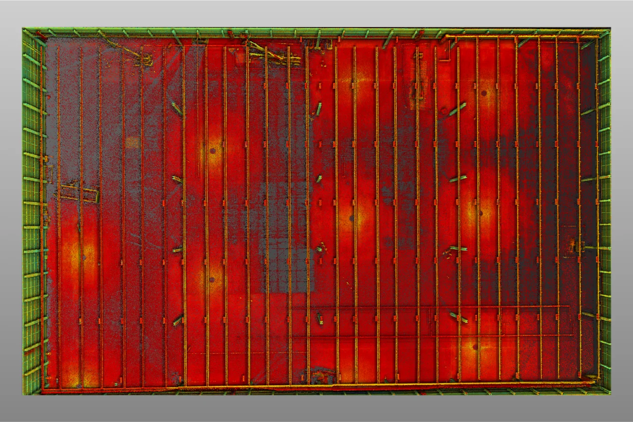 Aerial view of a square red metal surface with parallel greenish-yellow beams, some visible rust and discoloration. The edge is green with bolts, resembling the industrial roof of a BMW Industrial Plant or a shipping container.