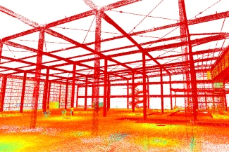 Una imagen de nube de puntos 3D coloreada muestra la estructura de acero interior de un gran edificio en construcción en Ciudad de México, con vigas, columnas y objetos dispersos visibles. Los puntos rojos, amarillos y naranjas indican diferentes elevaciones en Cinépolis Mitikah.