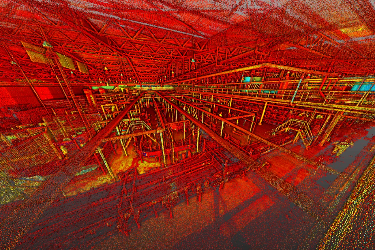 Nube de puntos digitalizada en 3D de una planta industrial de Coca Cola, que muestra una compleja red de tuberías y estructuras metálicas bajo un tejado de celosía, en vibrantes tonos rojos, amarillos y naranjas.