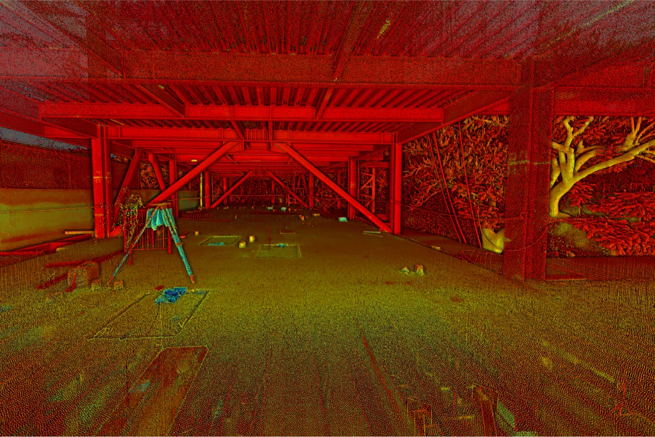 Una estructura abierta, de estilo industrial, con vigas de acero rojo y tejado parcialmente abierto, domina frondosos árboles y arbustos bañados en luz dorada: una vívida instantánea de vida urbana dentro del desarrollo de Corteza Residencial. El suelo está salpicado de objetos diversos.