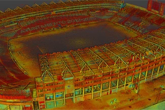 Aerial view of the Nou Camp stadium with stands and a partially covered roof; banners and advertisements can be seen around the stands.