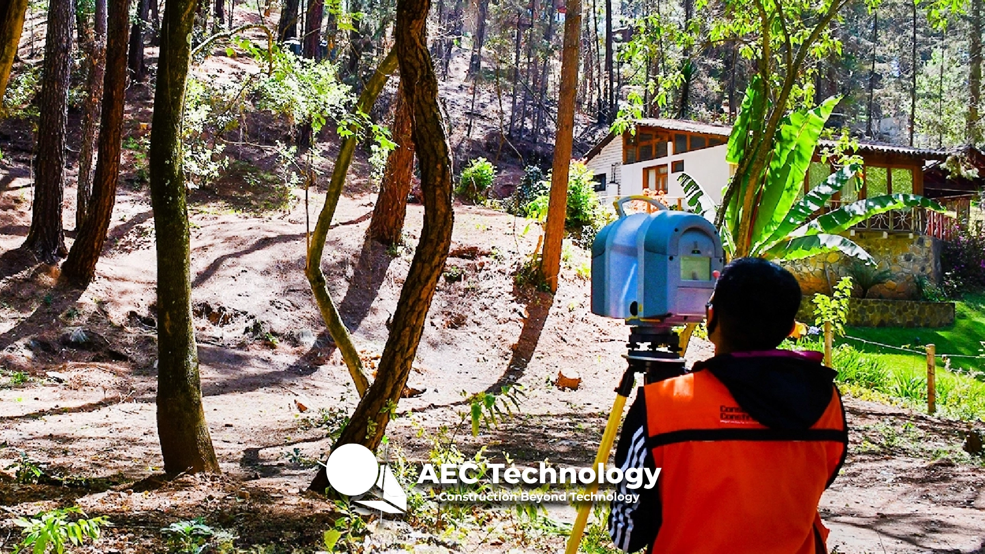 Una persona con chaleco de seguridad naranja inspecciona una zona boscosa con un escáner láser, realizando un levantamiento topográfico, con una casa visible entre los árboles al fondo. En la parte inferior aparece el texto "AEC Technology - Construction Beyond Technology".