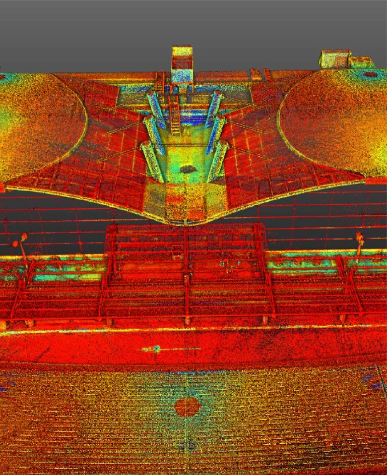 Colorida nube de puntos LiDAR 3D de una estructura con formas circulares y rectangulares, que probablemente representa un emplazamiento arquitectónico o industrial visto desde arriba, con puntos de datos rojos, amarillos, verdes y azules.