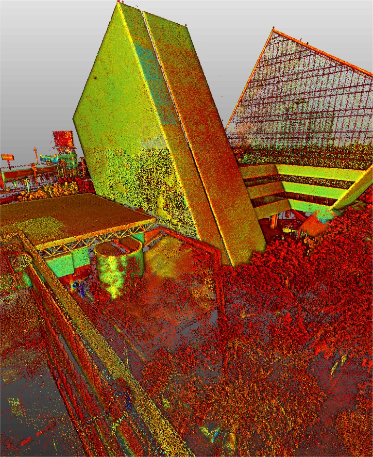 nubes de puntos -que recuerda a LiDAR en Monterrey- muestra dos grandes edificios angulares con formas triangulares, rodeados de vegetación y estructuras más pequeñas en vibrantes tonos rojos, amarillos y verdes.
