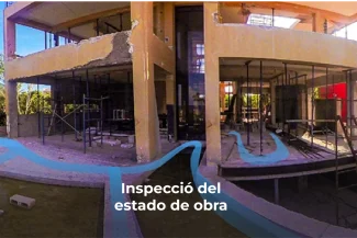 Un edificio parcialmente construido con andamios y paredes inacabadas, rodeado de árboles y luz solar. Líneas azules se curvan a través de la imagen con el texto Inspecció del estado de obra en la parte inferior central, mostrando Fotografía Digital Técnica.