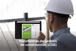 Una persona con casco blanco y gafas de seguridad sostiene una tableta que muestra una plataforma de gestión de la construcción. Fotografía Digital Técnica capta los detalles. El texto de la imagen dice: Plataformas de gestión de construcción (CDE).