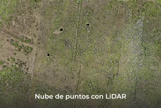 Imagen aérea de un terreno cubierto de vegetación, con varios puntos oscuros y líneas rectas visibles gracias a la tecnología LiDAR. En la parte inferior, el texto dice: Nube de puntos con LiDAR.