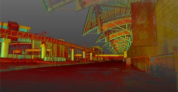 Un edificio grande y moderno con un tejado alto y curvado e intrincados soportes metálicos en una terminal vacía al aire libre -captado con sorprendente detalle por Escaneo LiDAR CDMX- rodeado de pasarelas y estructuras bajo un cielo oscuro.