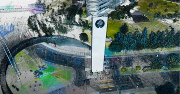 Nube de puntos LiDAR digital de una torre blanca rodeada de carreteras, árboles y zonas verdes en un parque urbano, vista desde arriba.